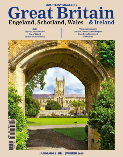 Cover Great Britain magazine winter 2025. Coverfoto: Een doorkijkje door een stenen poort richting de kathedraal van Bath